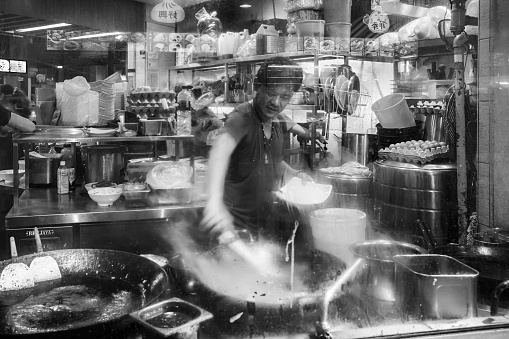 Singapore - September 07, 2019: Smiling street hawker vendor of Chinese stall in Lau Pa Sat, Telok Ayer Market hawker center, black and white