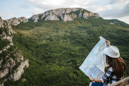 Woman holding a map on mountain peak