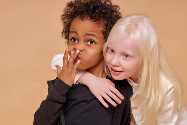 istock friendly albino girl hug multiracial boy from back 1225497593