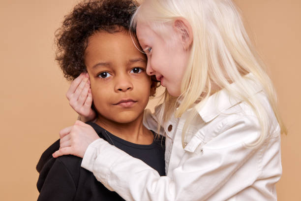 istock tender, sensitive albino girl hug african boy 1225497598
