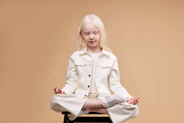 istock calm alien albino child sit meditating 1225497686