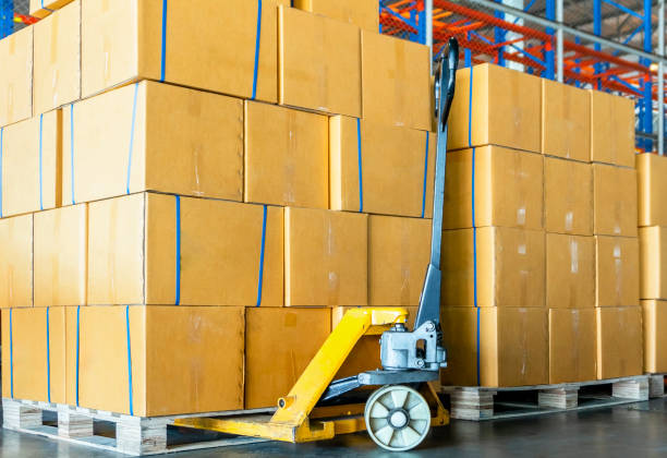 istock Stack of package boxes on pallets and hand pallet truck, cargo shipment in warehouse 1225499961