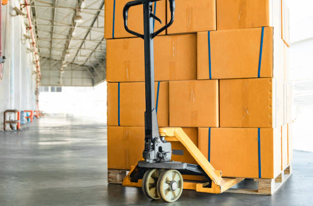 istock Stack of package boxes on pallets and hand pallet truck, cargo shipment in warehouse 1225499966