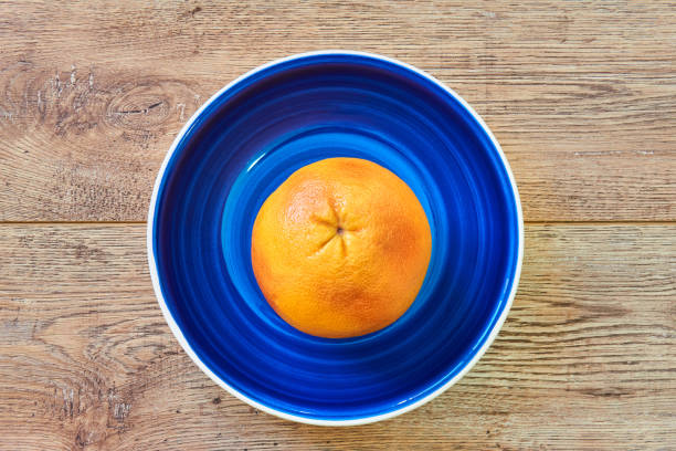 istock rosy yellow grapefruit on a bright blue plate on a wooden tabletop 1225502276