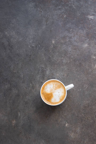 istock Cappuccino cup with milk foam on brown concrete background with copy space. Coffee time concept. 1225503537