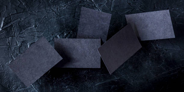 istock Thick black business cards panorama, flying on a dark background, a mockup for a creative design presentation 1225504264