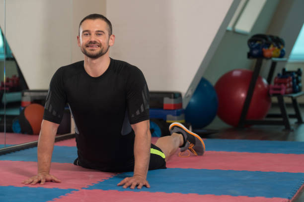 istock Healthy Young Man Stretches At The Floor 1225504420
