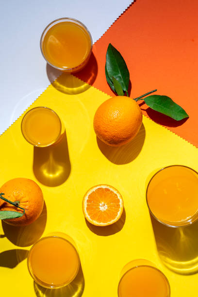 istock orange juice from above on colored backgrounds. 1225504574