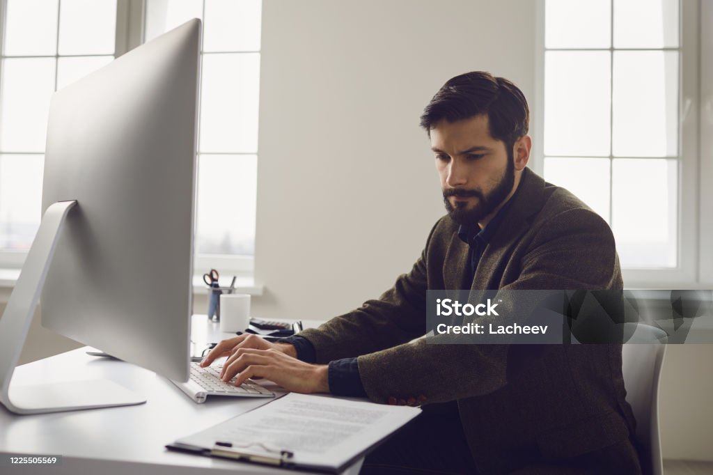 At The Computer Businessman Works At The Computer At The Table In The Workplace In The ...