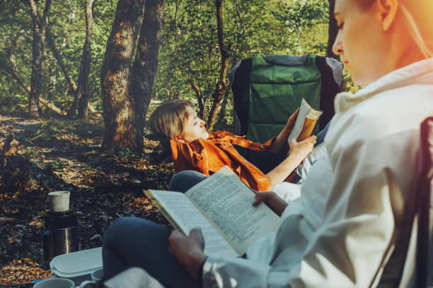 istock Two young girls relax on camping and read books 1225505755