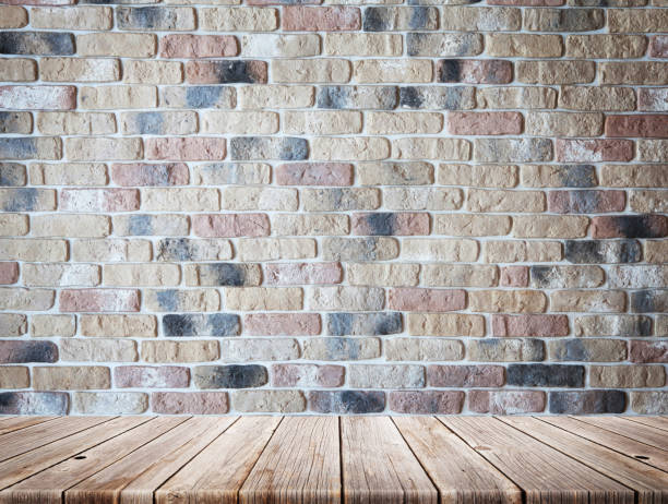 istock Wooden table in front of brick wall 1225505822