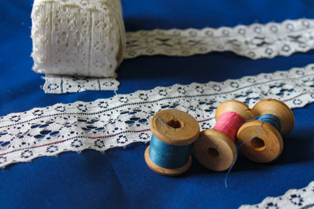 istock white lace on blue fabric, manufacturing process, spools of thread 1225506651