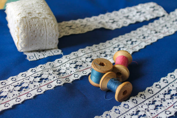 istock white lace on blue fabric, manufacturing process, spools of thread 1225506673