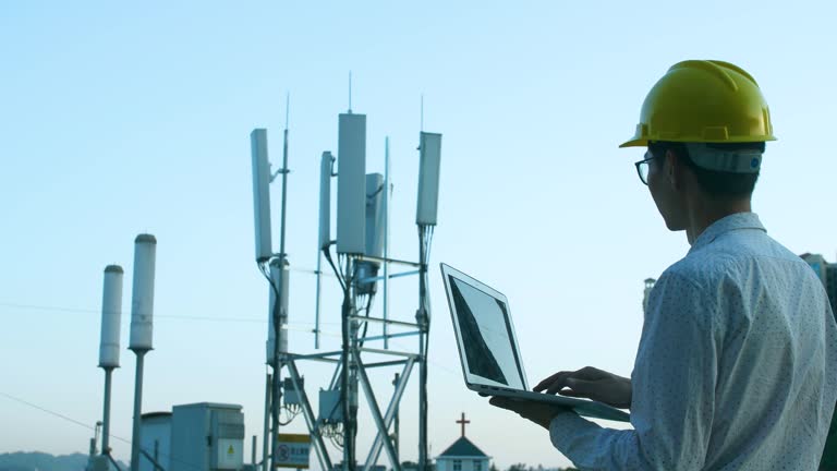 Engineer working on a laptop,Checking the communications tower