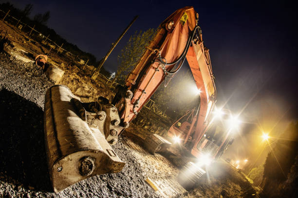 istock Orange excavator digger working at night on the street 1225509772