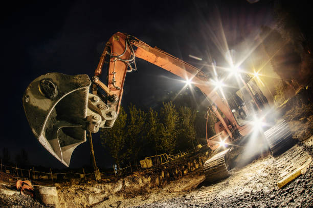 istock Orange excavator digger working at night on the street 1225509773