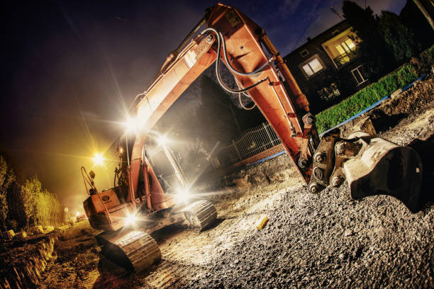 istock Orange excavator digger working at night on the street 1225509778