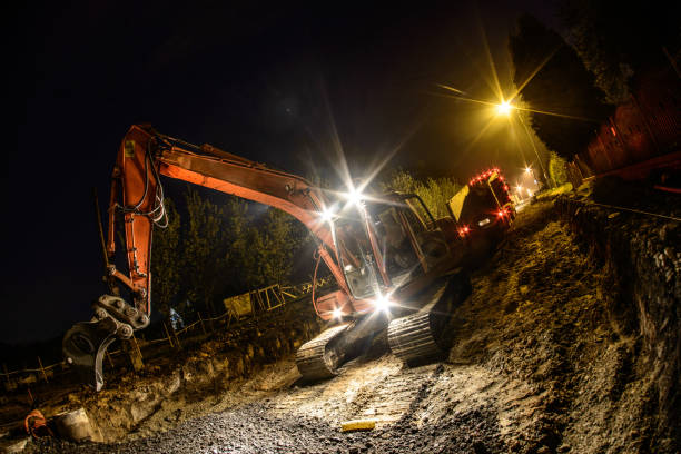 istock Orange excavator digger working at night on the street 1225509779