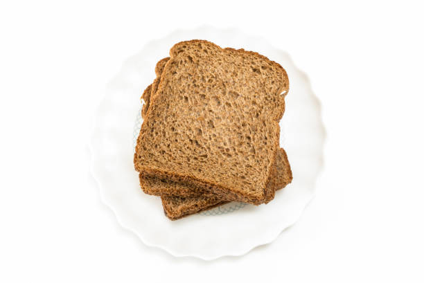 istock Whole grain sandwich bread slices on plate, on white background. 1225511049