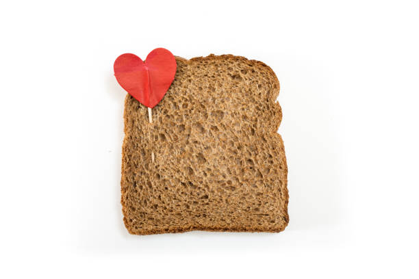 istock Whole grain sandwich bread slice with heart pin, on white background. 1225511075