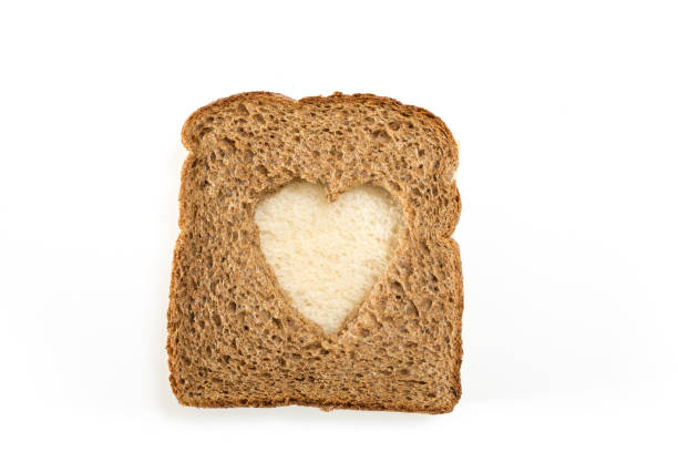 istock Whole grain sandwich bread slice with heart cut shape, on white background. 1225511077