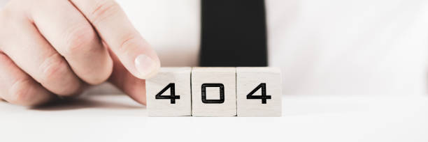 istock Businessperson assembling a sign 404 on white blocks in conceptual image for page not find error message 1225511463