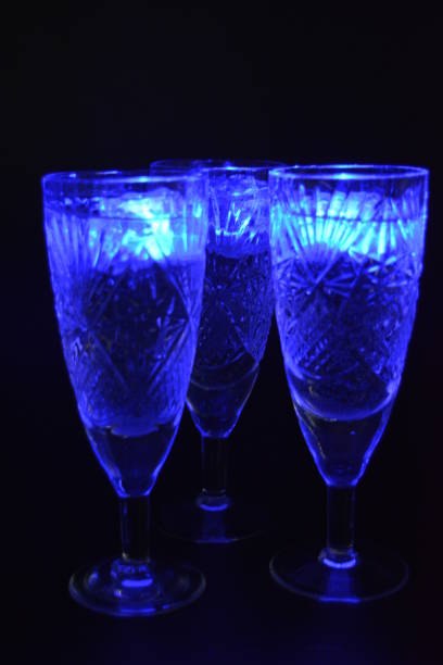 taças de champanhe de cristal com esculturas na forma de flocos de neve estão localizadas em um fundo fosco preto. brilhantes cubos de gelo dídicos multicoloridos flutuam na bebida. - patinagem no gelo - fotografias e filmes do acervo