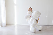 Beautiful little girl with big soft bear toy