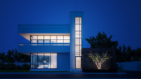 Modern house with white plaster with a balcony and a high staircase, in the cold evening light with warm light from the Windows against the background of trees and a white fence 3D stock illustration