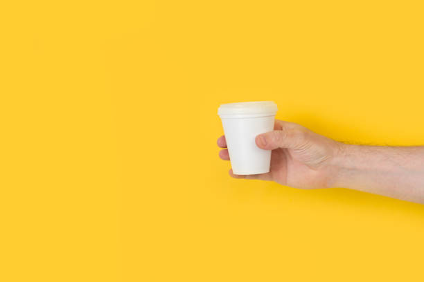使い捨ての白いカップを持つ男の手 - man’s hands ストックフォトと画像