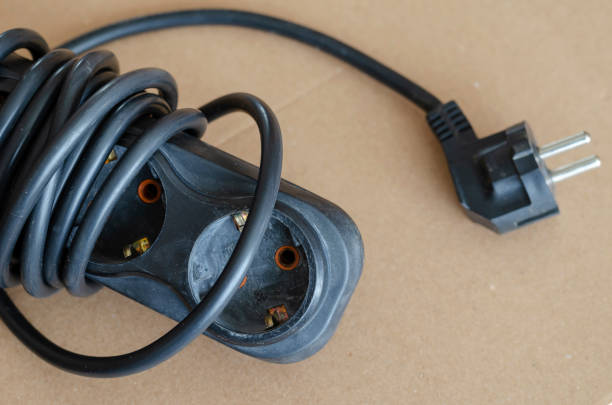 istock Old black extension cord on the floor close-up. 1225519127