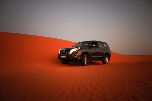 Merzouga, Morocco - September 24, 2019: Offroad car Toyota Land Cruiser Prado 150 in the dunes of the Sahara desert.