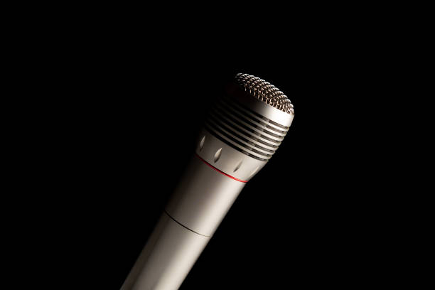 istock audio microphone on stand in black dark background, copy space 1225521988