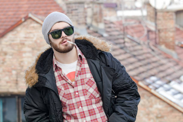 istock Young man with cigarette posing on the street. 1225524648
