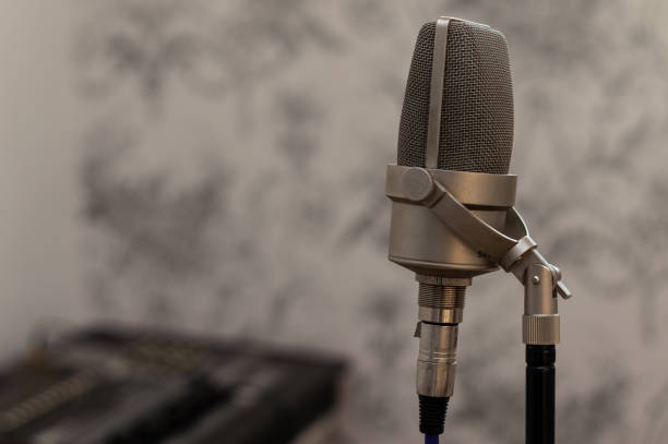istock Microphone up close with mixing desk in background. 1225525099