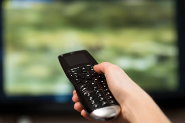 istock Woman watching tv with focus on his hands on the remote control 1225525519