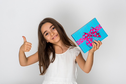 A Beautiful Young girl Holding A Gift Box.Showing thumbs up