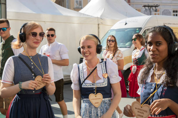 beautiful young women in bright national costumes posing for photo during traditional festival - dirndl traditional clothing austria traditional culture imagens e fotografias de stock