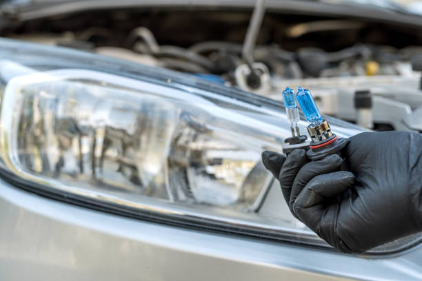 istock Repairment holding new car light bulb under deception for headlamp, car as background 1225531447