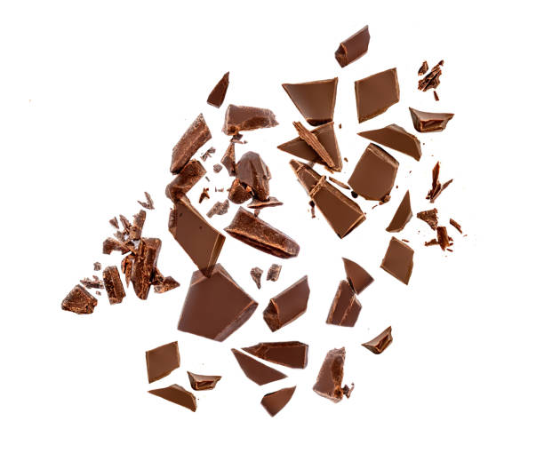 istock Chocolate pieces and shavings isolated on white background. Chunks of dark chocolate falling close up 1225533833
