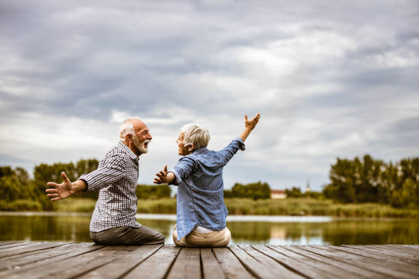 istock Happy senior couple having fun on a pier at river. 1225535113