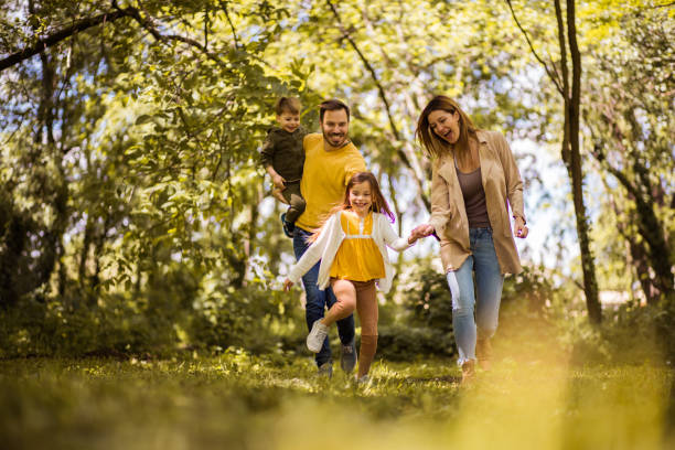 нам всегда нравится время семейных связей. - family fun running couple стоковые фото и изображения