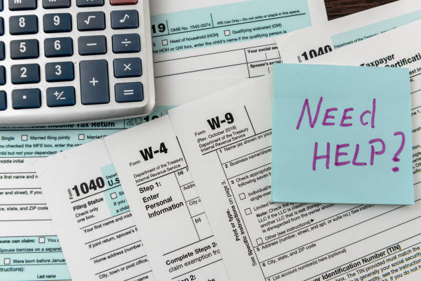 istock Sticker with text Need Help and 1040 tax form, pen and calculator. Deadline 1225538257