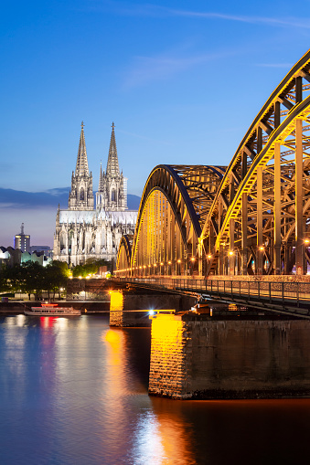 The metropolitan cathedral of Saints Peter and Mary of Cologne resumed at sunset together with the Hohenzollern bridge, a famous railway bridge where the padlocks of lovers are hung, on the banks of the Rhine river at sunset.