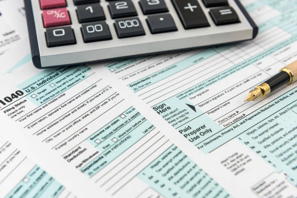 istock Tax form, pen and calculator at office desk 1225540042
