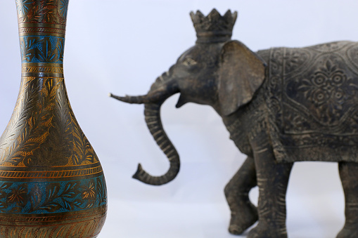Indian souvenirs. Bronze vase and defocused Indian elephant.