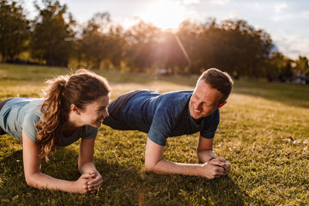 istock Happy athletic couple talking in plank position at the park. 1225544043