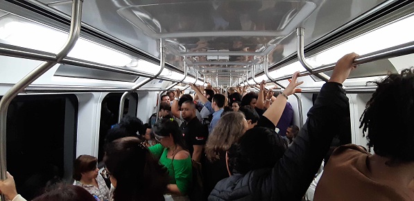 View Of People Sitting Down, Standing, Reading Text Message With Smartphone, Looking Around, Talking To One Another Inside Metro In Rio De Janeiro Brazil