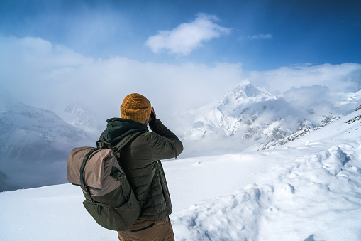 Traveler takes a picture of the snowy mountains