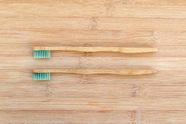 istock Set of two bamboo toothbrushes on wood background. Zero waste, biodegradable material, environment concept 1225544971